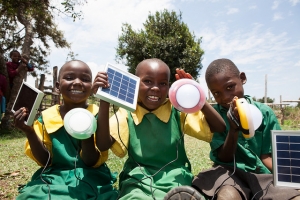 Primary school students holding solar lights in Kenya.